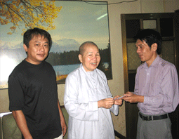 Ni sư Hoa Tâm cùng người thân trao số tiền đóng góp cho đại diện Báo CATP