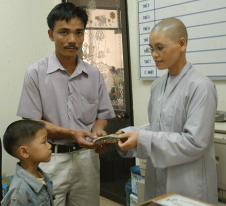 Trao số tiền 11,9 triệu đồng do bạn đọc giúp bé Lưu Anh Huy cho đại diện gia đình (ảnh chụp ngày 8-7-2009)