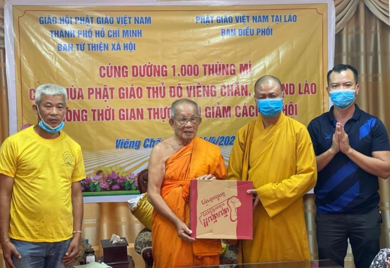 Thượng tọa Thích Minh Quang, đại diện Ban Từ thiện xã hội GHPGVN TP.HCM trao quà đến Hòa thượng Bounma Symaphom - Ảnh: C.Phật Tích