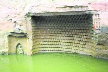 Một trong số những vách đá có khắc  hàng ngàn hình tượng Phật  cạnh một hồ chứa nước ở hạt San Su, tỉnh Tứ Xuyên.