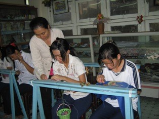 Em Thanh Thùy (bìa phải) trong một tiết học thêu